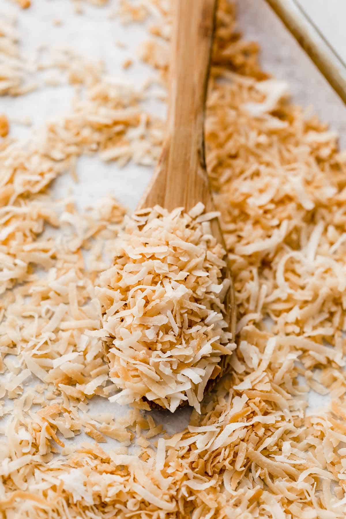 Toasted coconut on a wooden spoon.