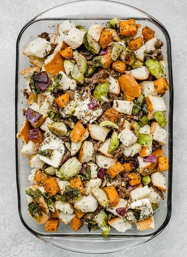 A casserole dish full of autumn vegetable stuffing prior to being baked.