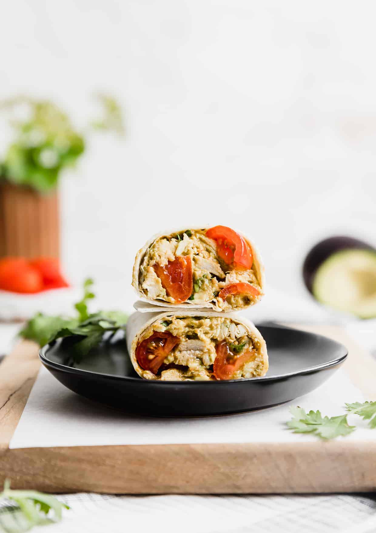 Avocado Chicken Wraps on a black plate.