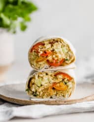 An Avocado Chicken Wrap cut in half, with the halves stacked on top of one another.