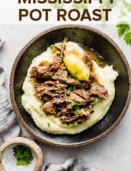 Mississippi Pot Roast on a bed of mashed potatoes with a garnish of parsley.