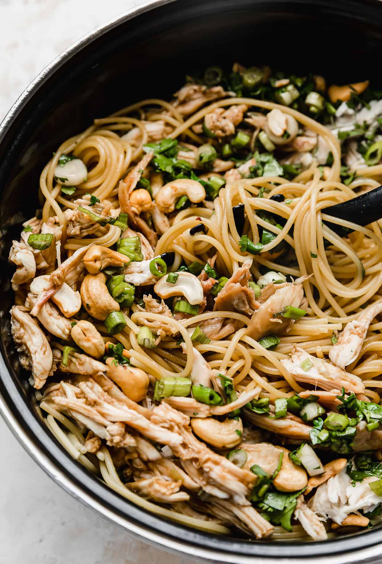 A pot filled with chicken Sesame Cilantro Noodles.