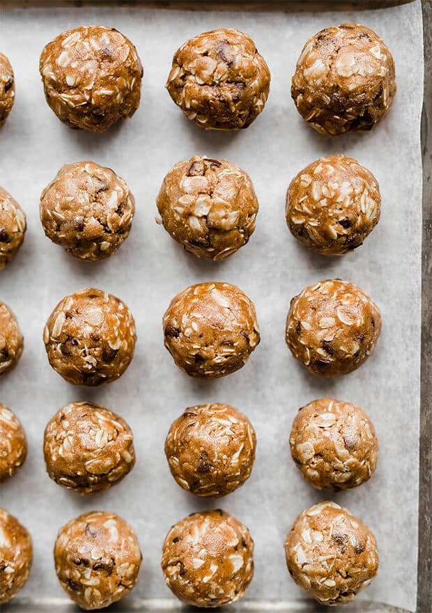 A sheet lined with small Chocolate Peanut Butter Protein Balls.