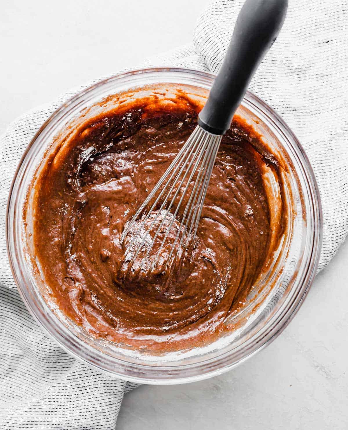 German Chocolate Brownie batter in a glass bowl on a white background.