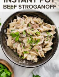 A bowl of beef stroganoff garnished with fresh parsley.