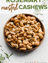 Rosemary Roasted Cashews on a plate with rosemary sprigs scattered about.