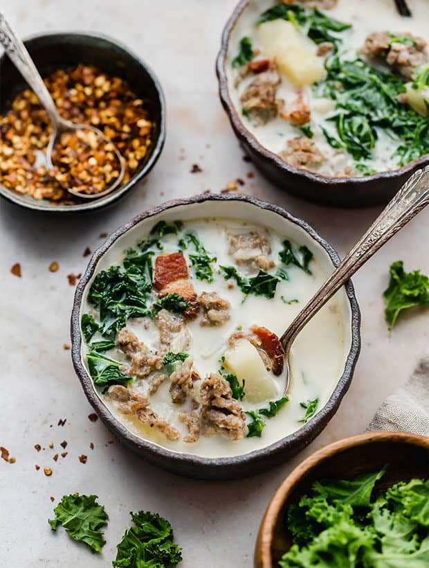 A bowl of Copycat Zuppa Toscana with a spoon in the bowl.
