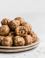 Chocolate Peanut Butter Protein Balls on a plate with one ball having a bite taken out of it.