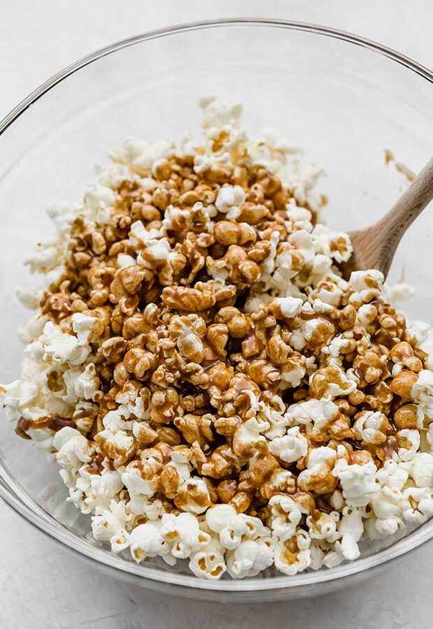 A large bowl of popcorn with the cinnamon caramel poured overtop.