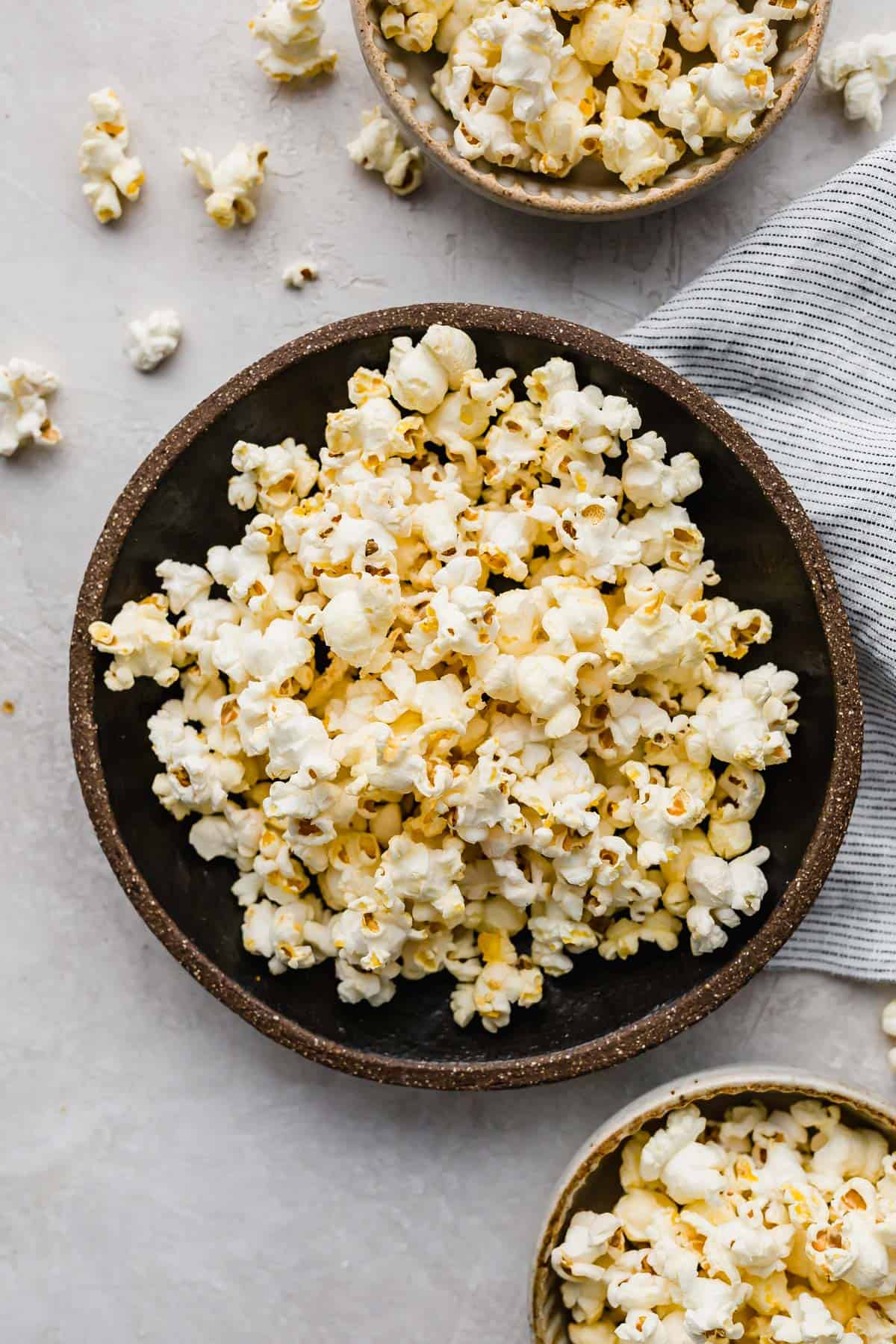 Movie Theater Popcorn made at home, in a black bowl on a white background.