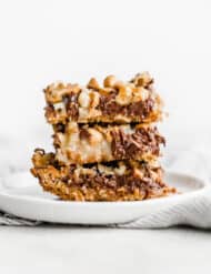 7 Layer Bars stacked on each other on a white plate against a white background.