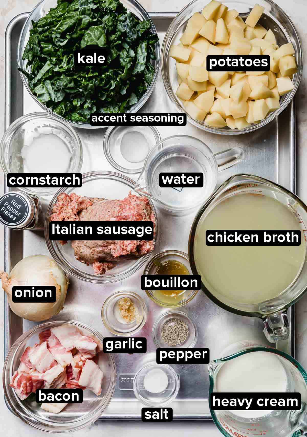 Olive Garden Zuppa Toscana Soup ingredients portioned into glass bowls on a silver baking sheet.