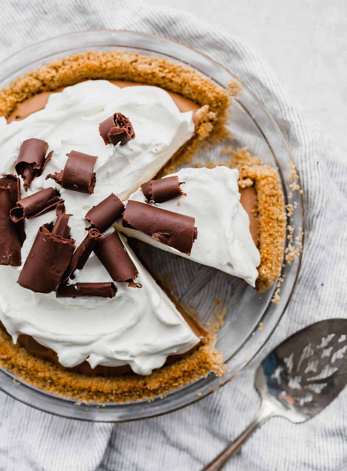 Overhead photo of a whipped cream topped French Silk Pie on a white background.