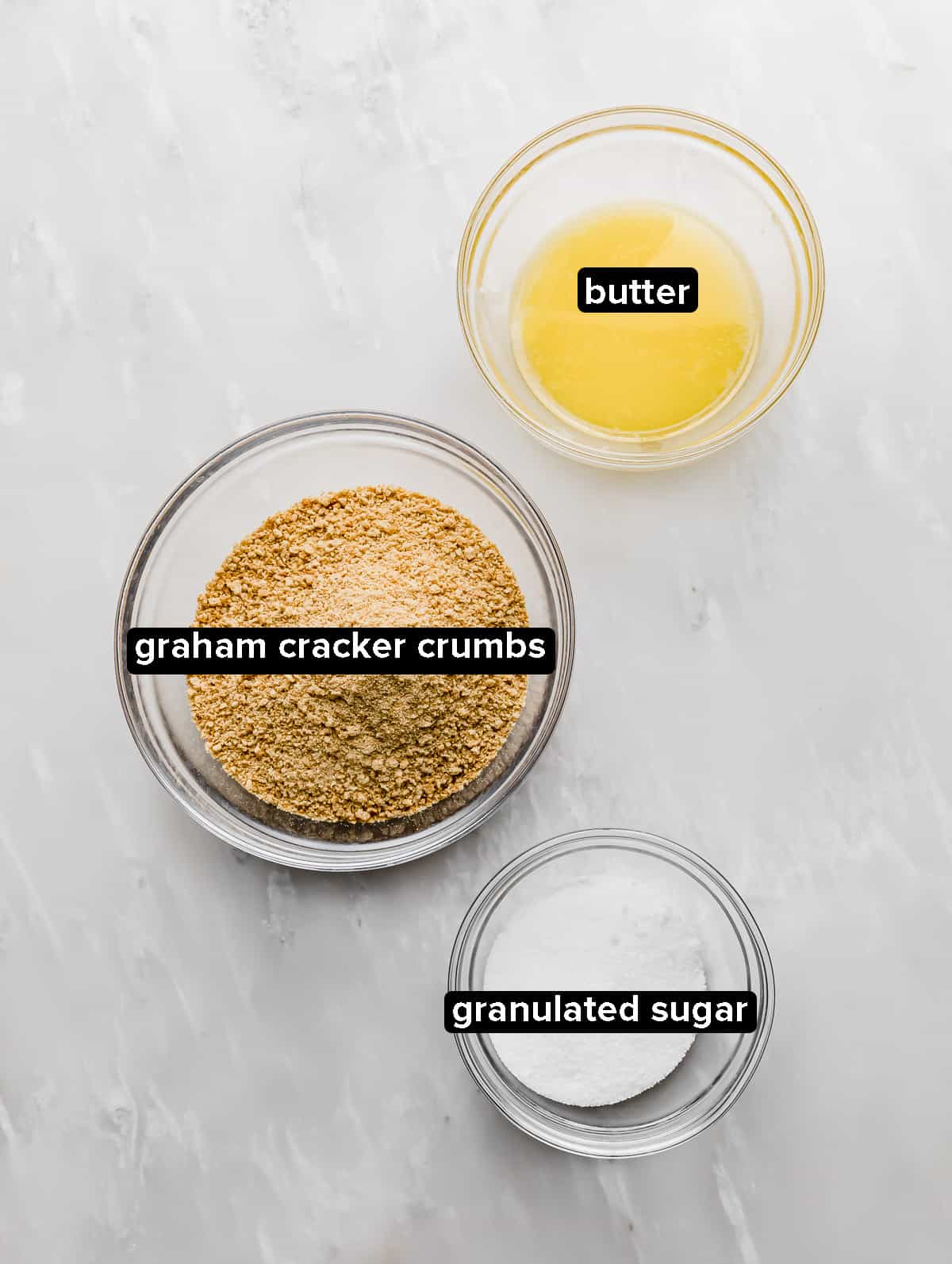Graham Cracker Crust ingredients on a white marble background.