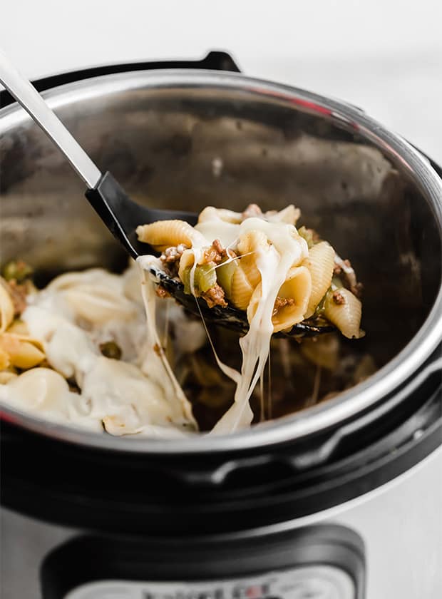 A spoon scooping up Instant Pot Philly Cheesesteak Pasta from the Instant pot. 