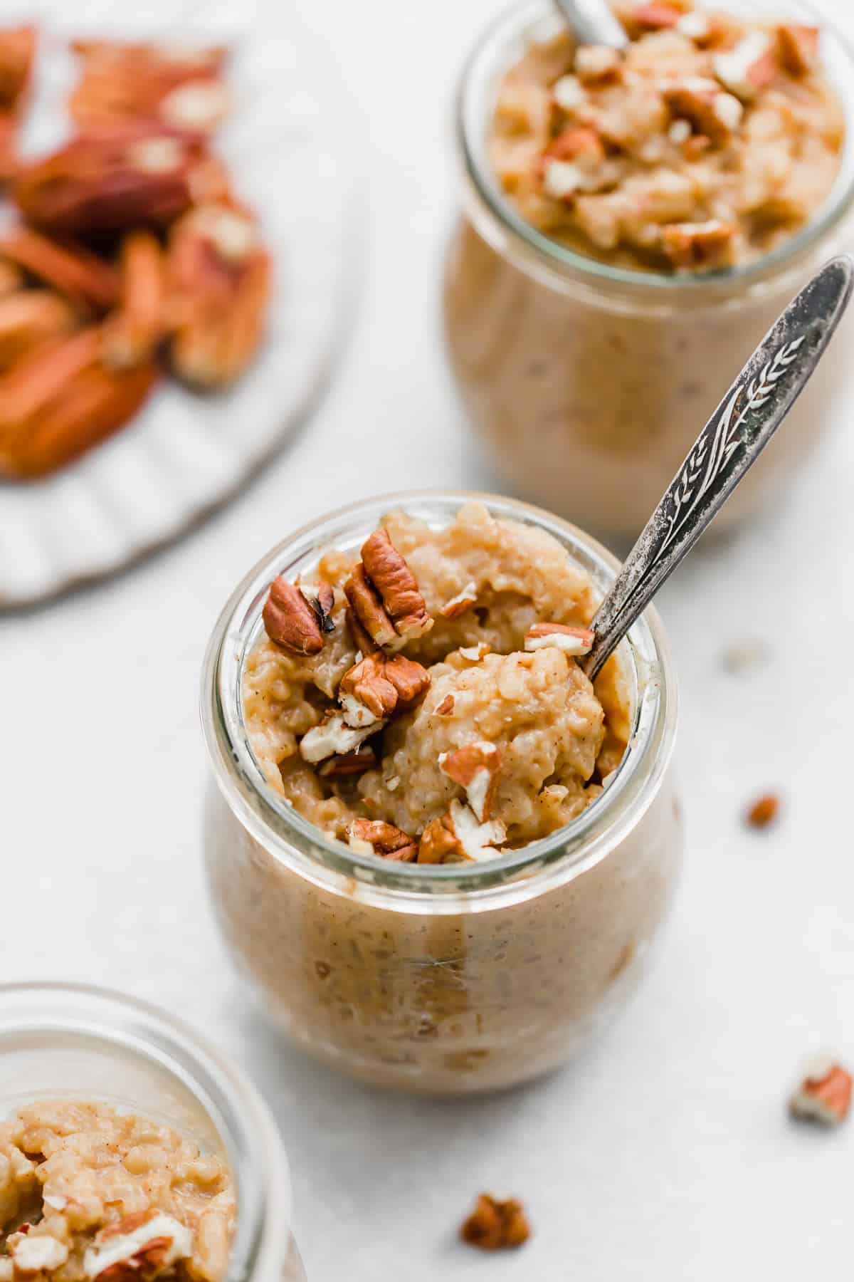 Pumpkin Rice Pudding topped with pecans in a glass jar.