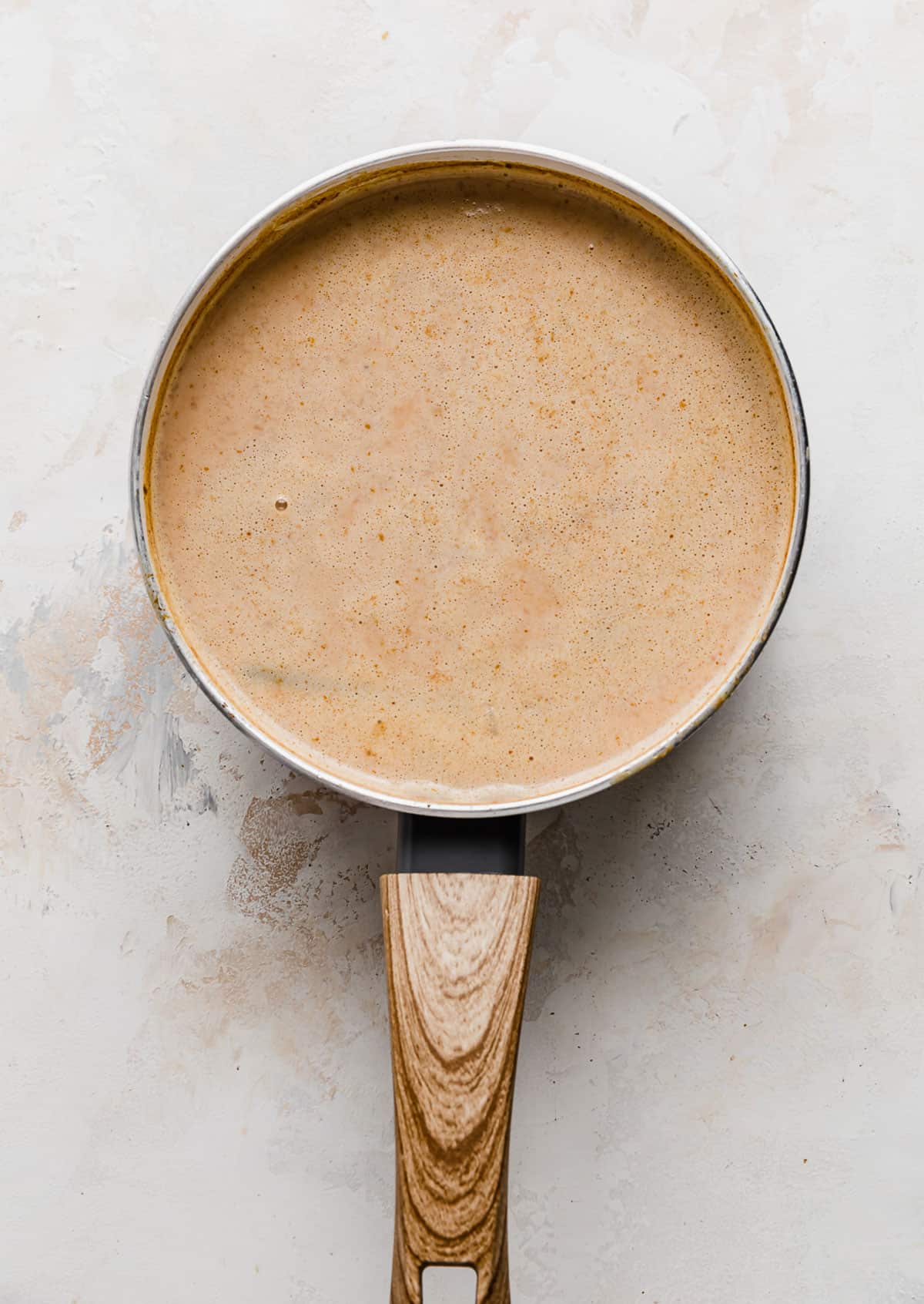 A light brown liquid mixture in a saucepan.