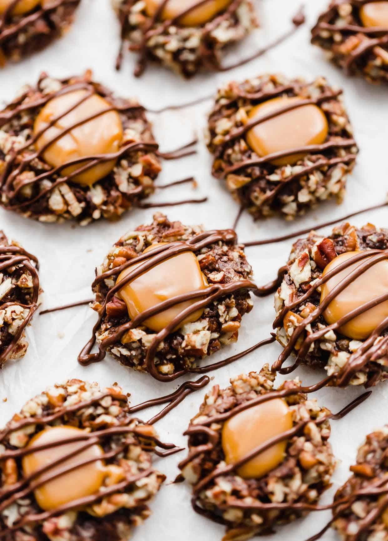 Chocolate Turtle thumbprint cookies with caramel and chocolate drizzled overtop. 
