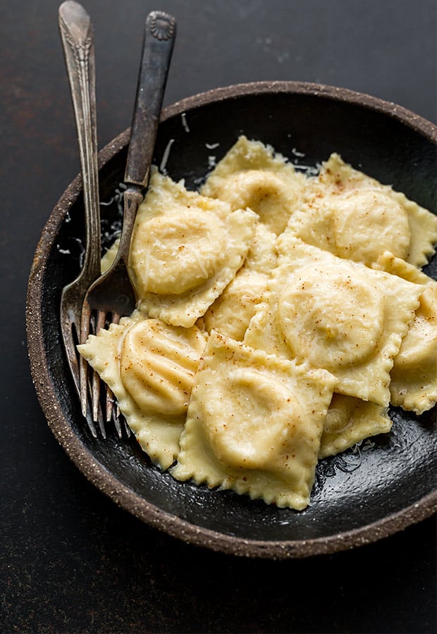 A bowl full of butternut squash filled ravioli.