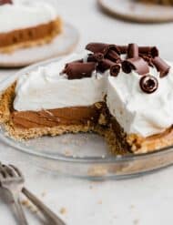 A French Silk Pie on a graham cracker crust with a slice removed from the full pie.