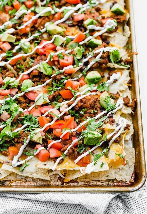 Loaded nachos on a baking sheet.