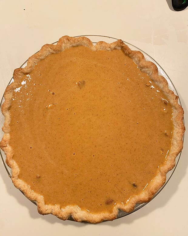 A pie crust filled with pumpkin pie filling.