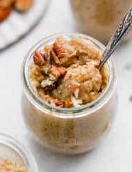 Pumpkin Rice Pudding in a glass jar on a white background.