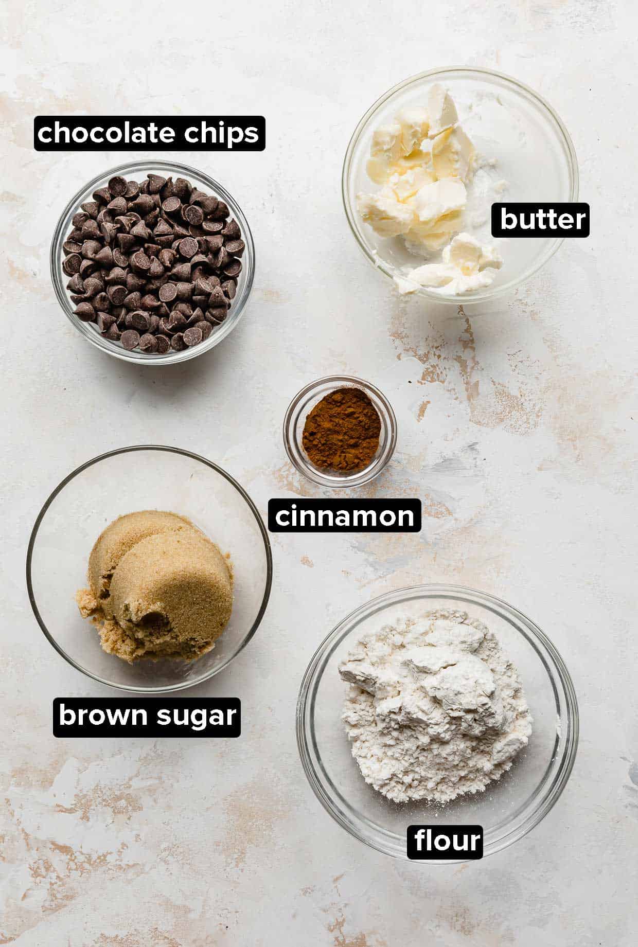 Cinnamon Chocolate Chip Coffee Cake topping ingredients portioned into glass bowls on a white background.