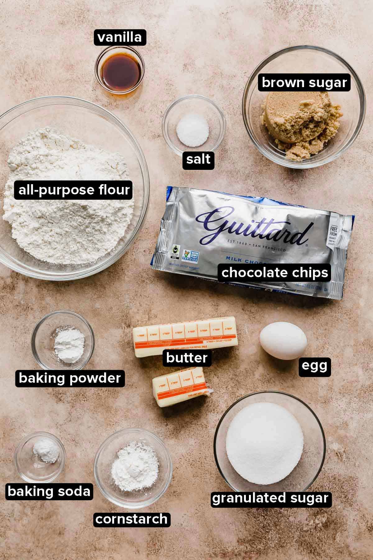 Crumbl Chocolate Chip Cookie Recipe ingredients on a light brown background.