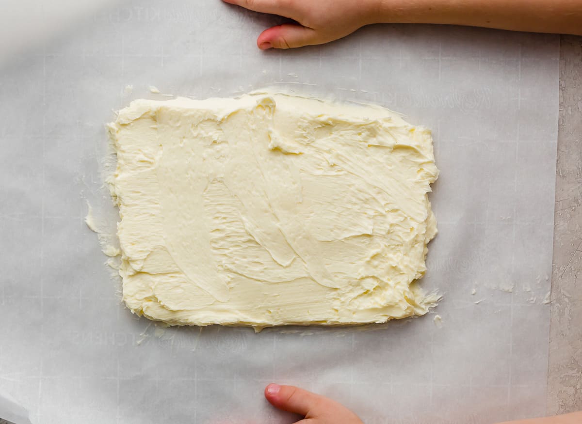 Butter flattened and smoothed into a rectangular shape on a parchment paper.