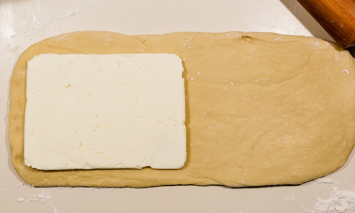 A square of flattened butter on brioche bread dough, ready to begin the laminating process.
