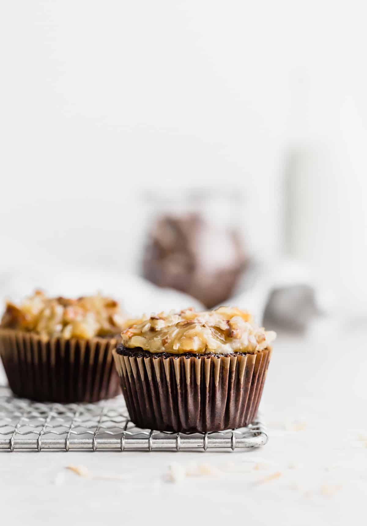 A frosted German Chocolate Cupcake against a white background.