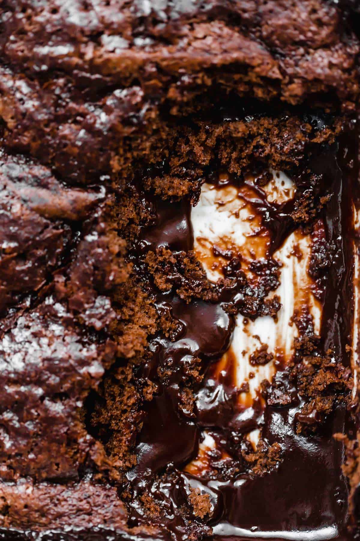 A close up photo of hot fudge cake removed from a baking dish, leaving behind the cake crumbs and hot fudge.