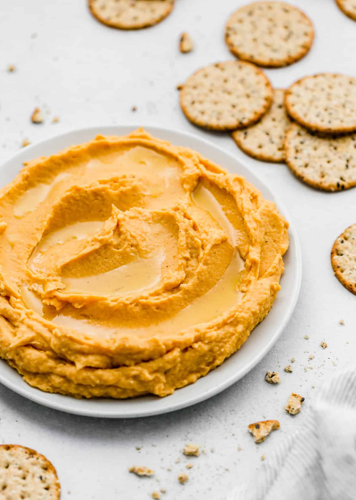 Sweet Potato Hummus on a plate with crackers surrounding it.