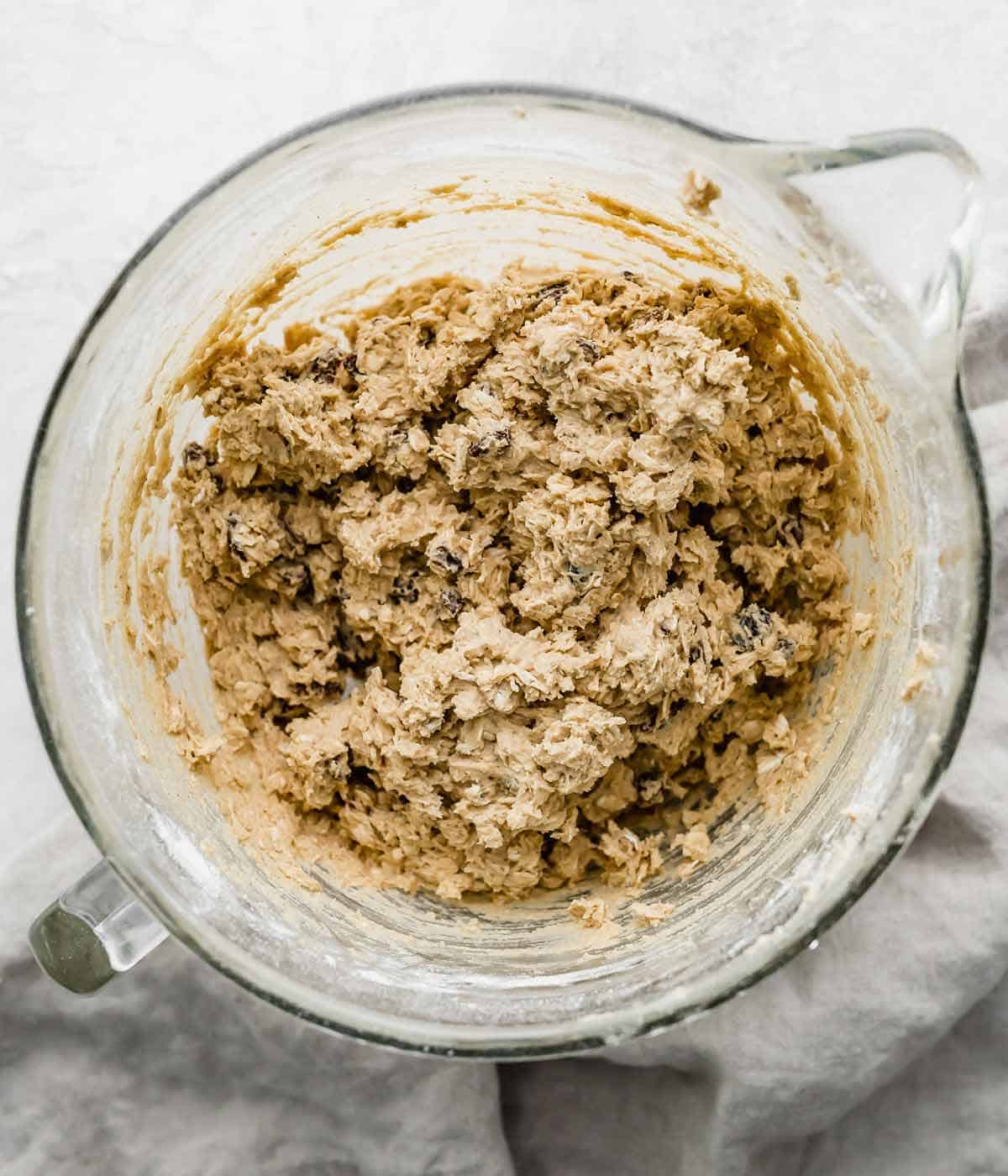 Soft Oatmeal Raisin Cookie dough in a glass mixing bowl.