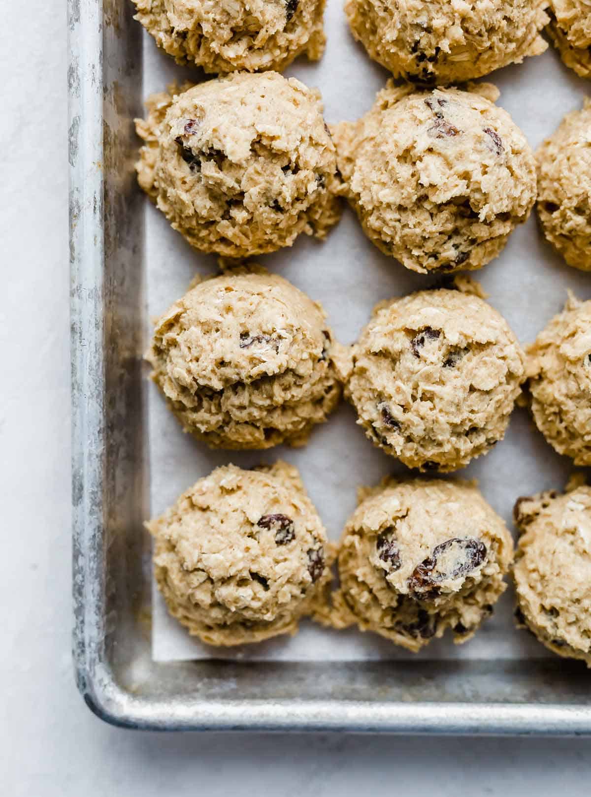 Oatmeal raisin cookie dough balls on a baking sheet.