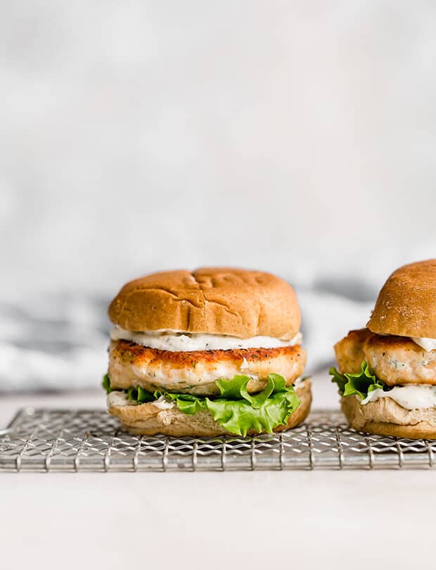 Salmon burgers on a bun with lemon dill mayo and lettuce.