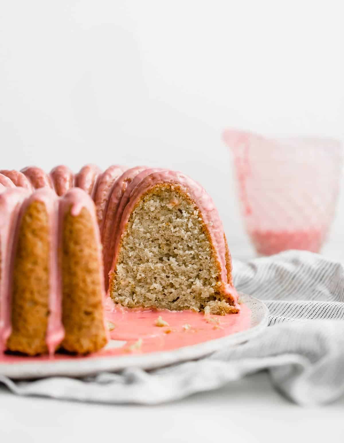 A blood orange bundt cake with cardamom cut, showing the soft interior.