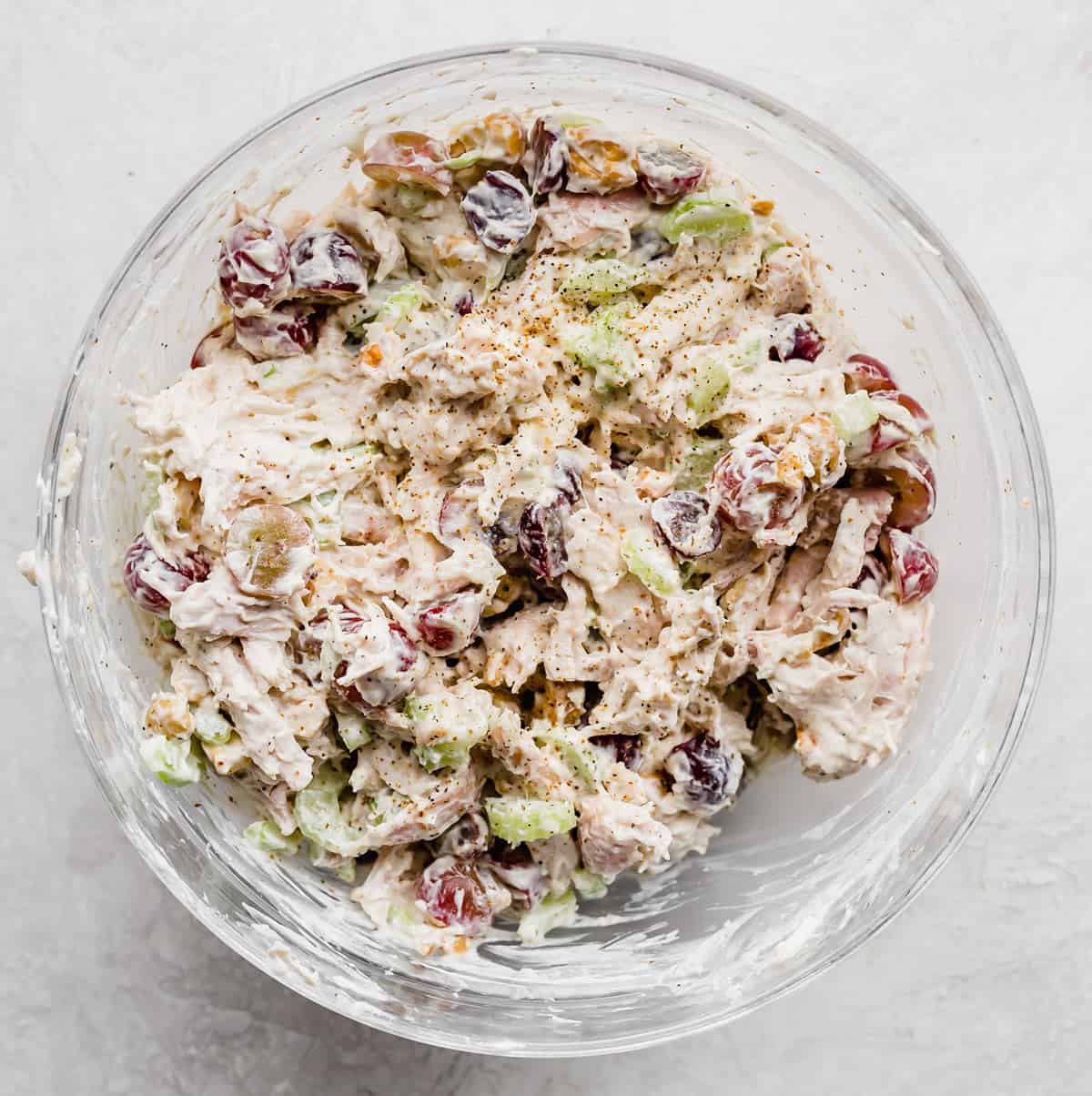 Chicken Salad filling in a glass bowl on a light gray background.