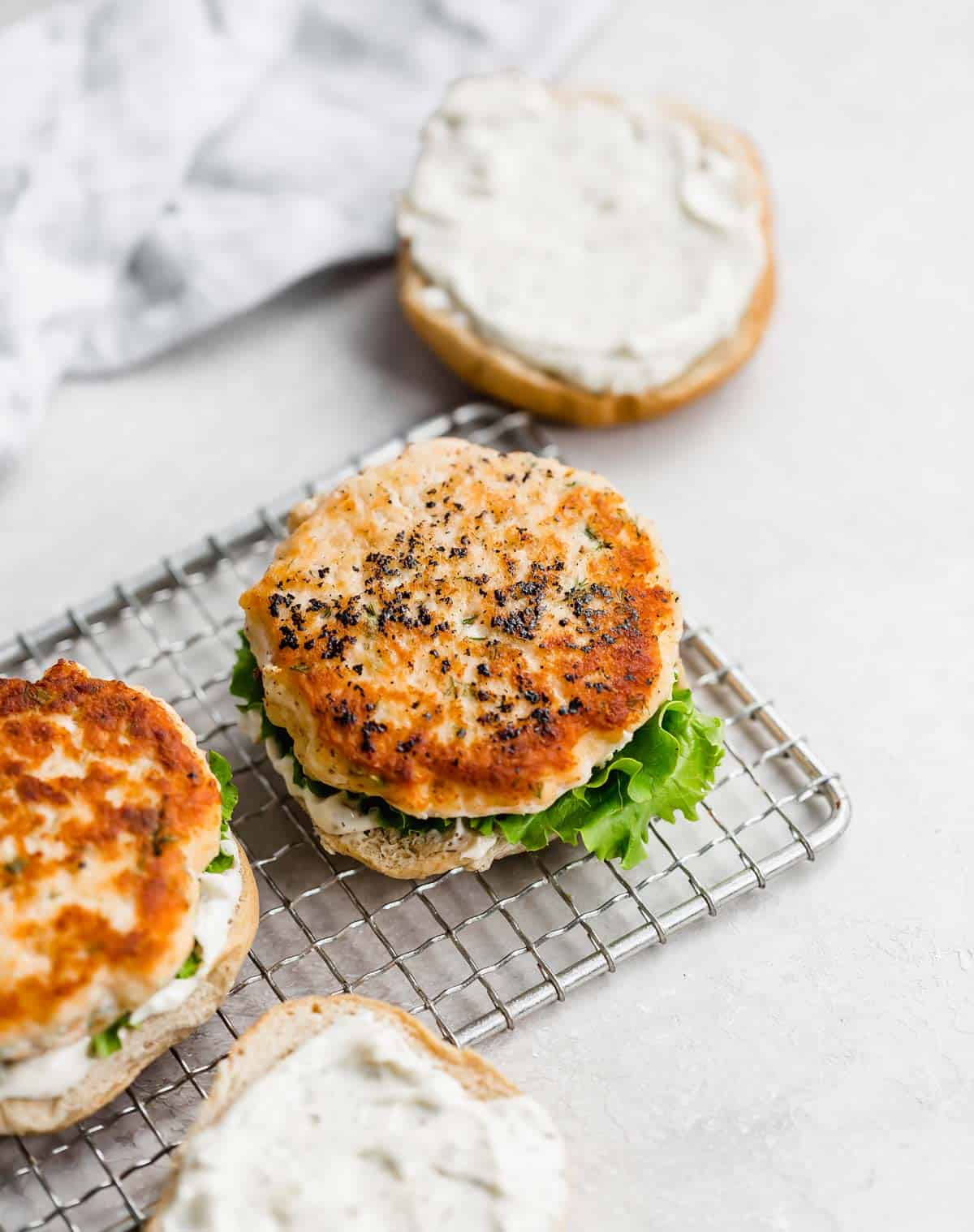 An easy to make salmon burger on a bun with lettuce and a lemon dill sauce.