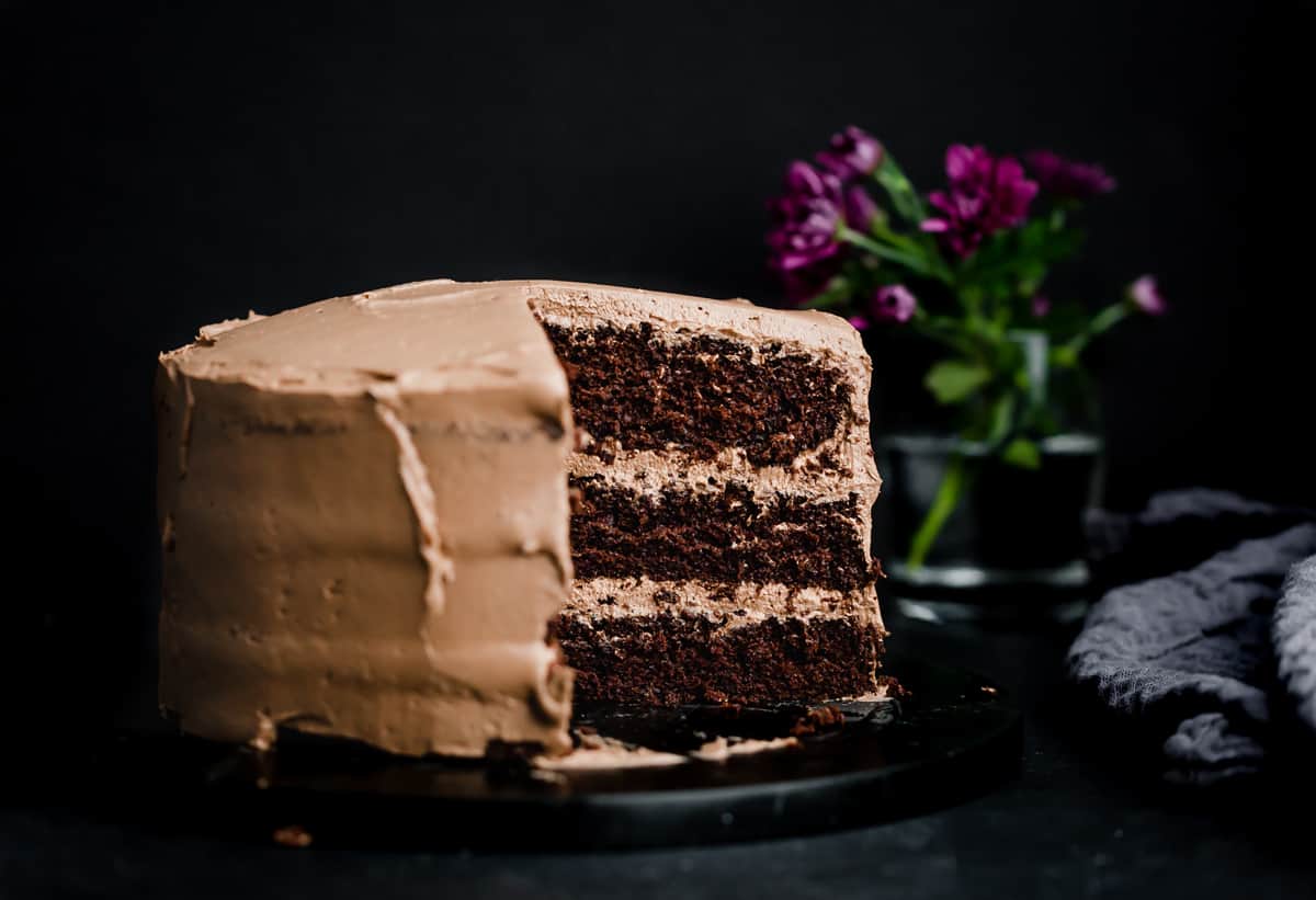 A Moist three layer Chocolate Cake made with Oil, on a black background.