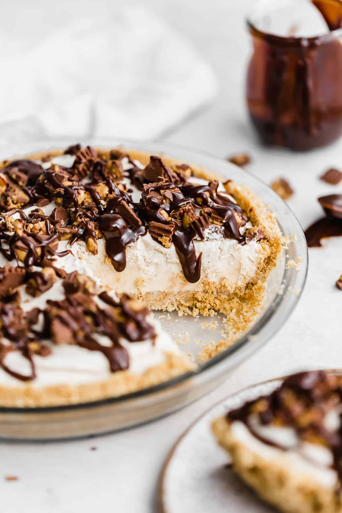 Hot fudge drizzled overtop a No-Bake Peanut Butter Pie in a graham cracker crust.