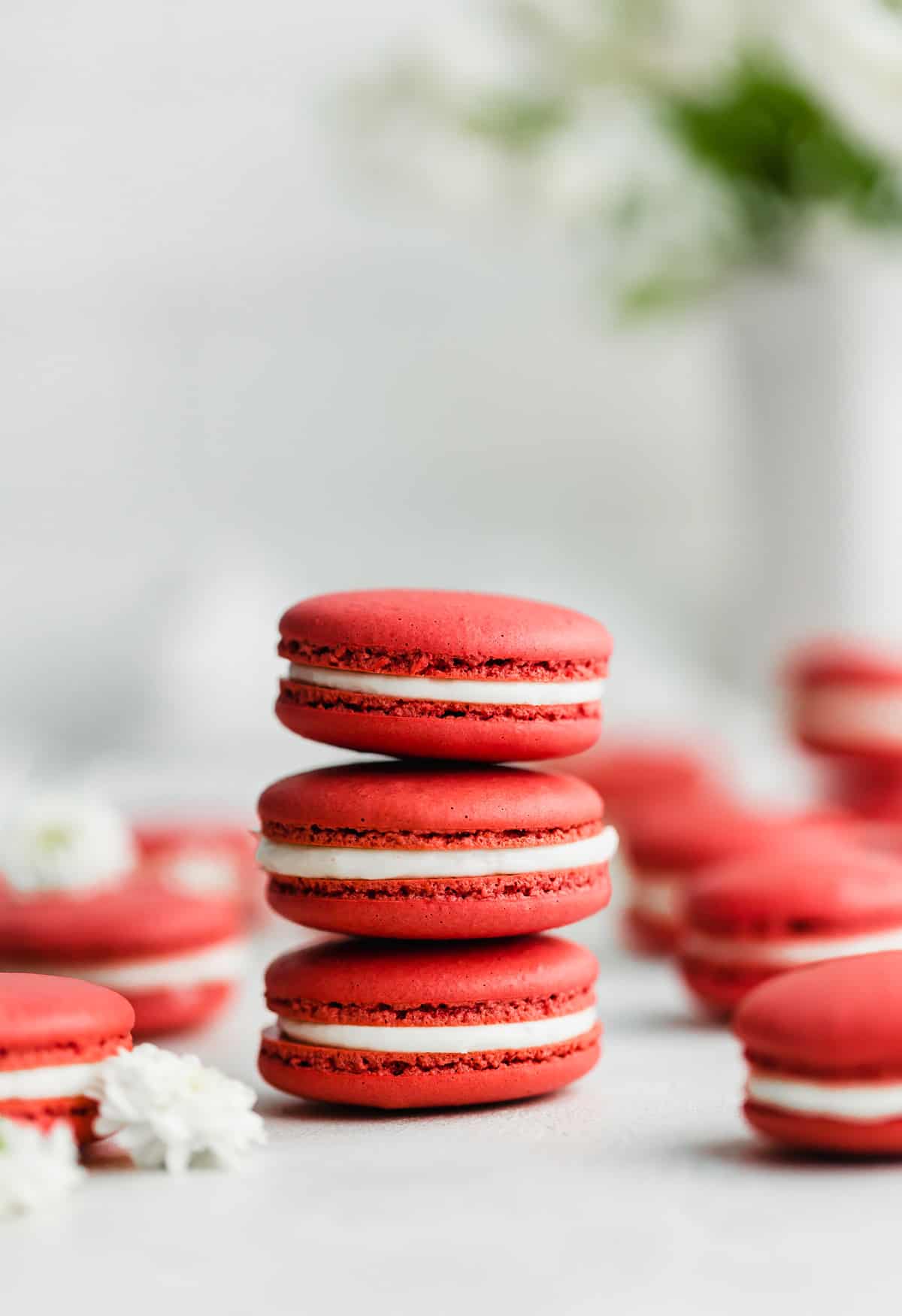 Three Red Velvet Macarons stacked on top of each other, against a white background.