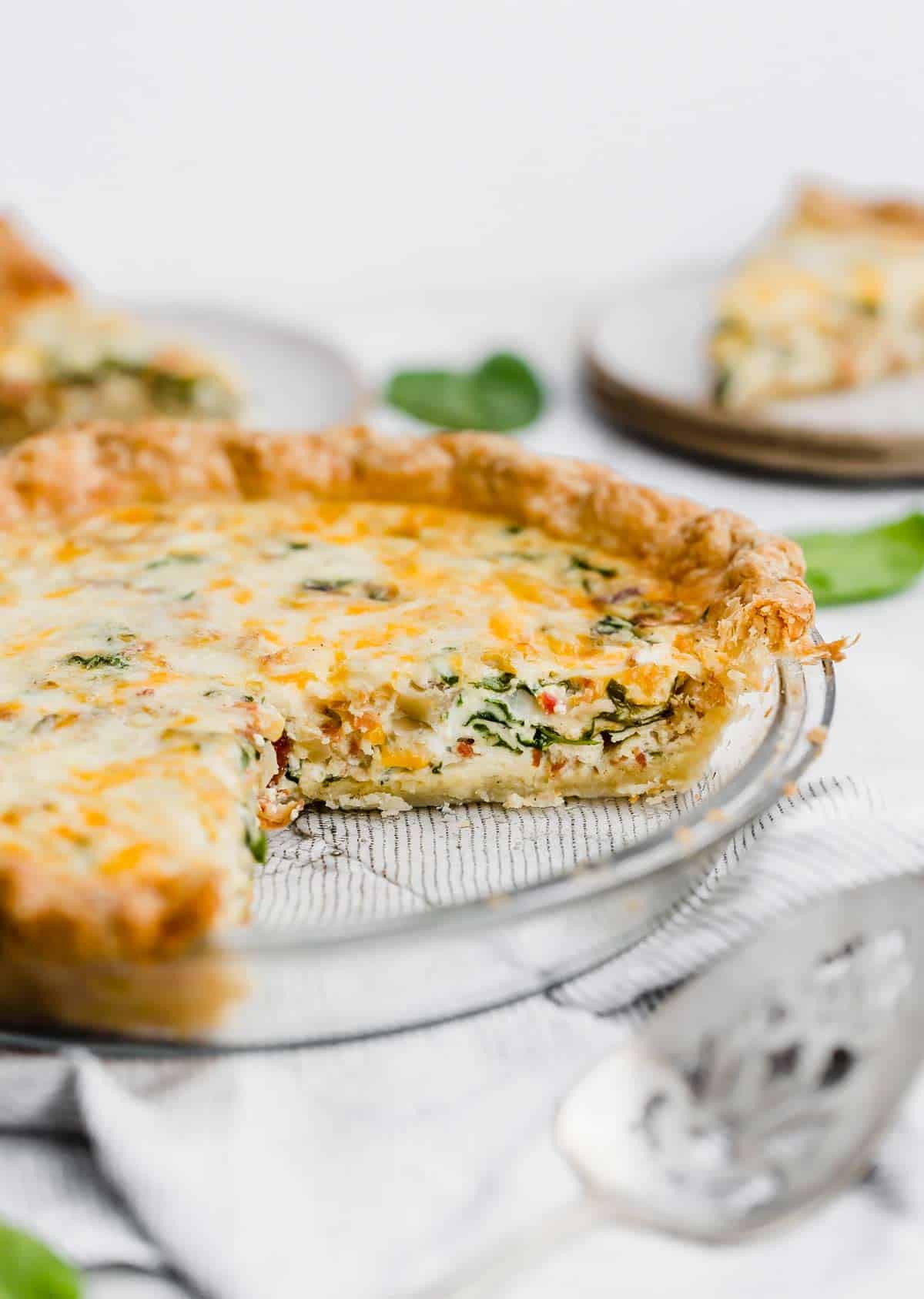 Spinach and Bacon Quiche in a pie plate.