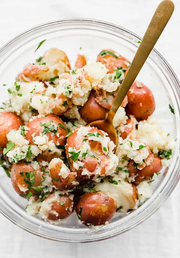 Buttery parsley potatoes in a glass bowl. 