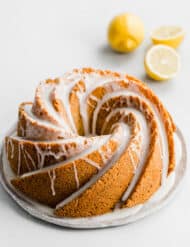 A ,Lemon Poppy Seed Bundt Cake covered in a lemon glaze against a white background.