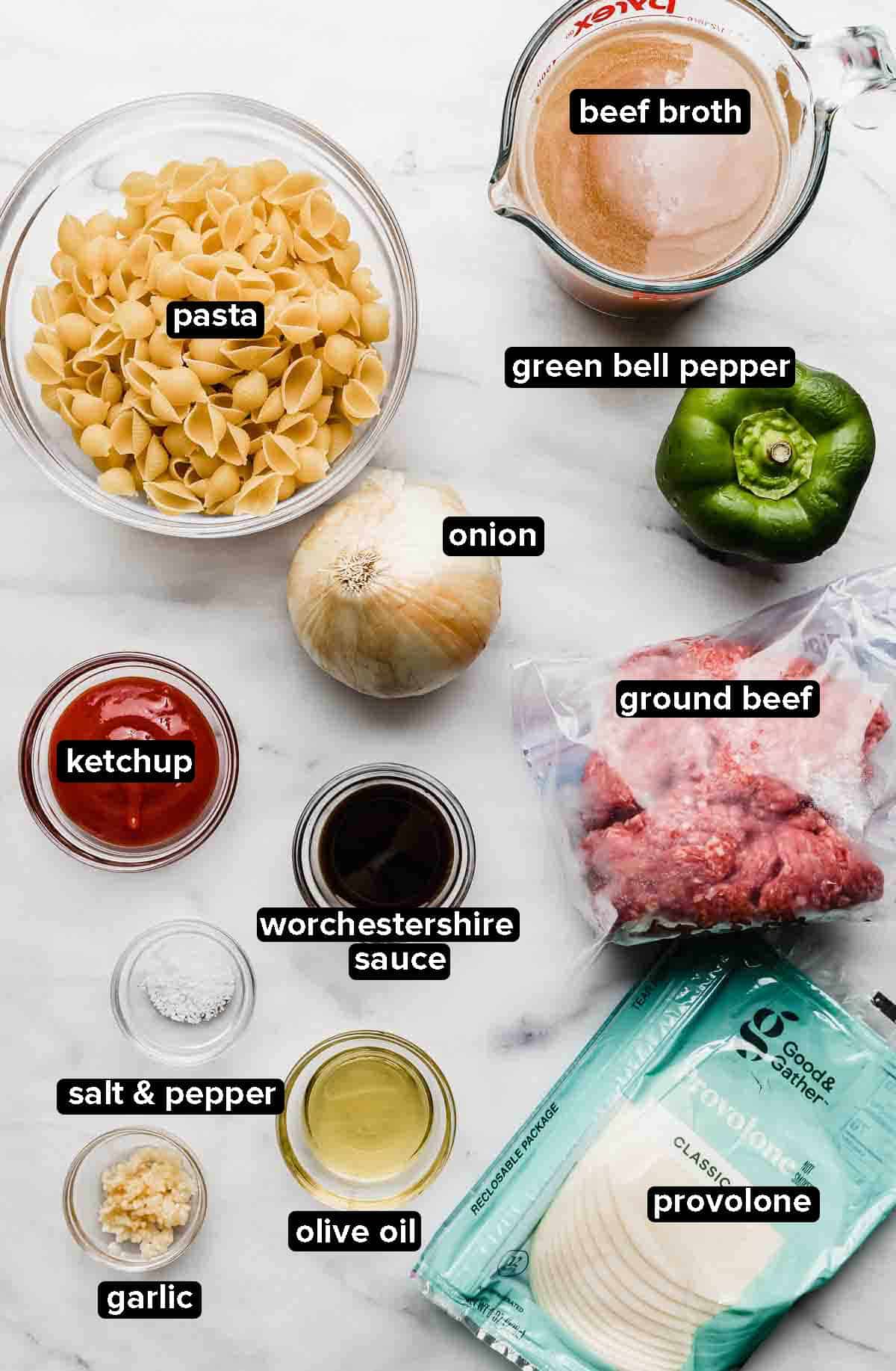 Instant Pot Philly Cheesesteak Pasta ingredients on a white marble background.
