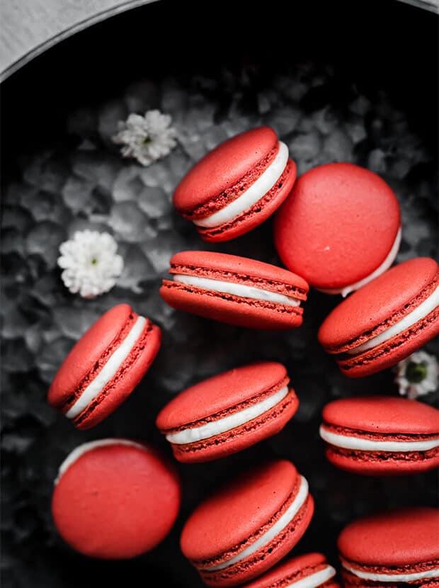 Macarons de terciopelo rojo sobre un fondo de metal.