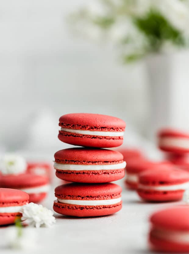 Una pila di 3 Macarons di velluto rosso su uno sfondo bianco.