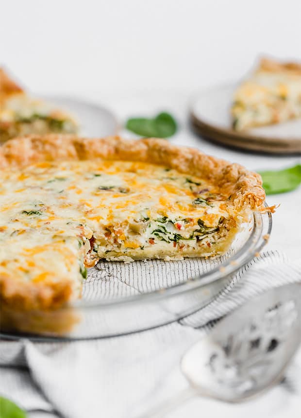A pie pan with a Spinach and Bacon Quiche.